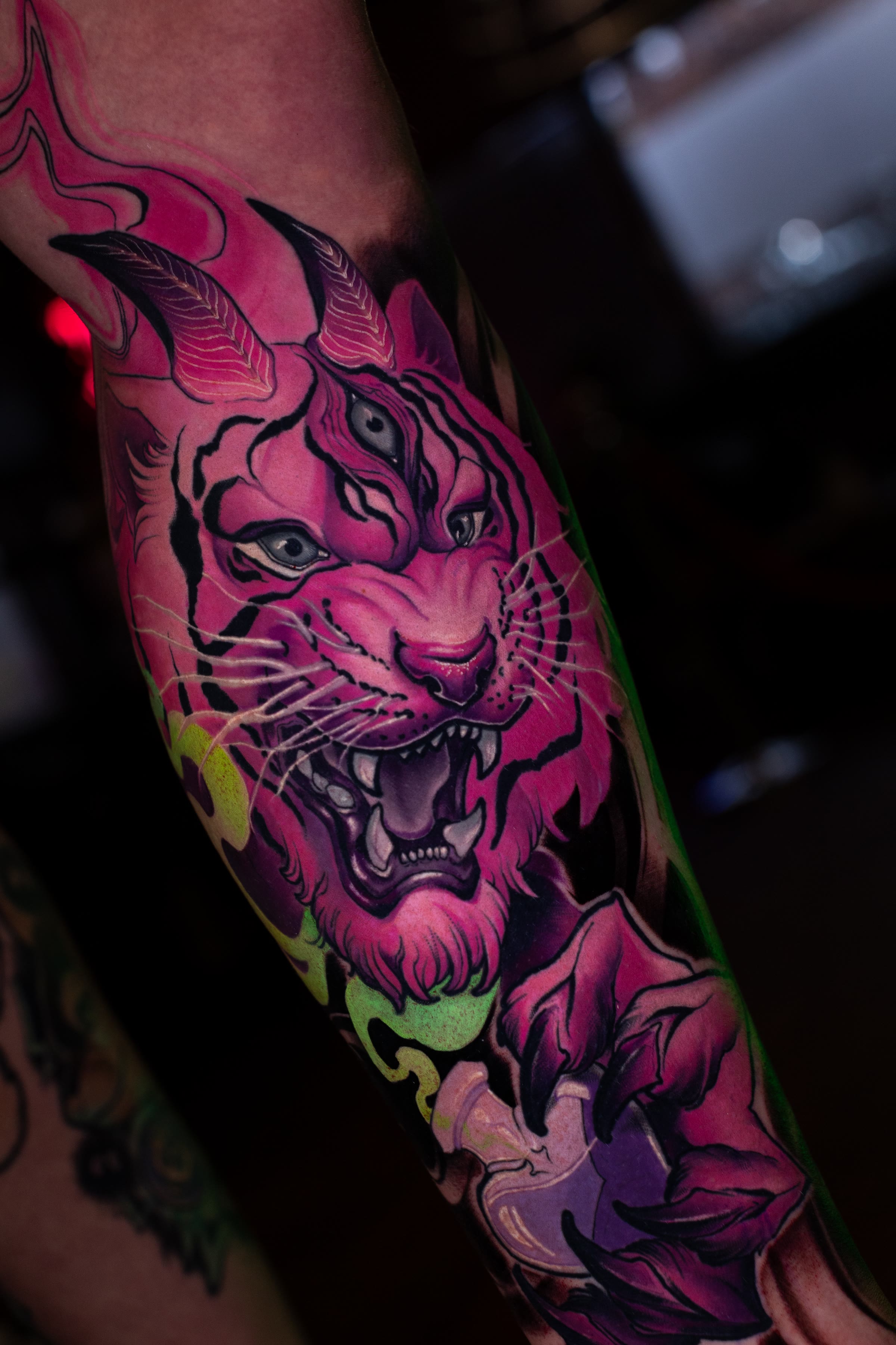 Colour illustration tattoo by veda.ink: a pink and purple tiger with a third eye, on a lower leg